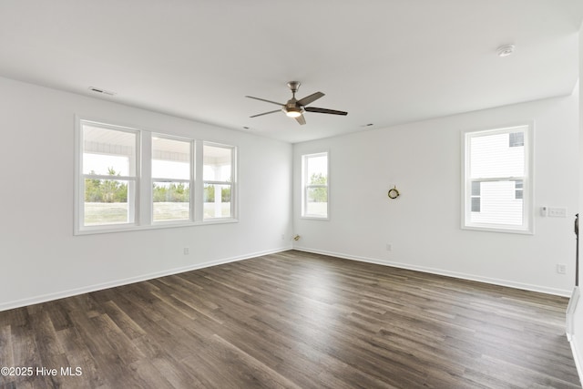 spare room featuring visible vents, dark wood-style flooring, and baseboards