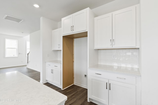 kitchen featuring dark wood-style floors, visible vents, light countertops, white cabinetry, and backsplash