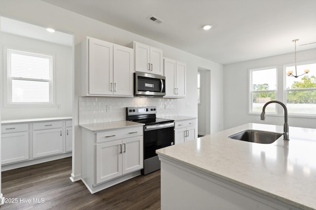 kitchen with electric range, visible vents, dark wood-type flooring, a sink, and stainless steel microwave
