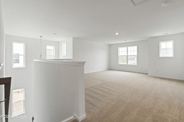 unfurnished room featuring baseboards and light carpet