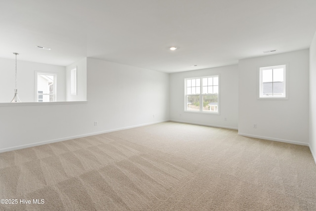 unfurnished room featuring light carpet, visible vents, and baseboards