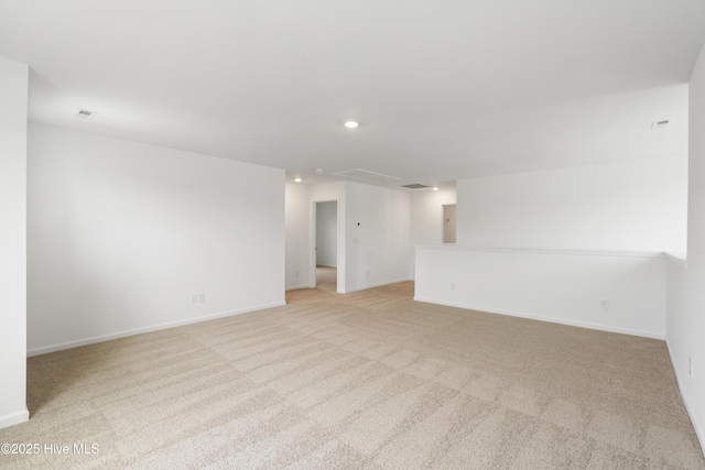 empty room featuring light carpet, recessed lighting, and baseboards