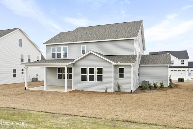 back of house featuring central AC unit, a patio area, and a shingled roof