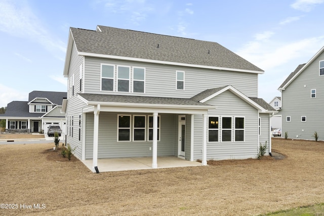 rear view of property featuring a patio area and roof with shingles