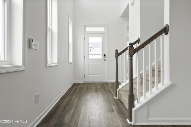 entrance foyer with stairs, baseboards, and dark wood-style flooring