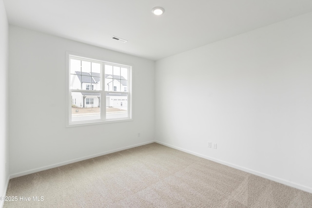 unfurnished room with visible vents, baseboards, and carpet flooring