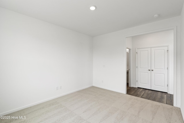 empty room with recessed lighting, baseboards, and dark carpet
