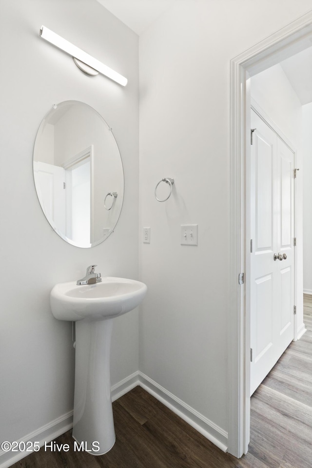 bathroom with baseboards and wood finished floors