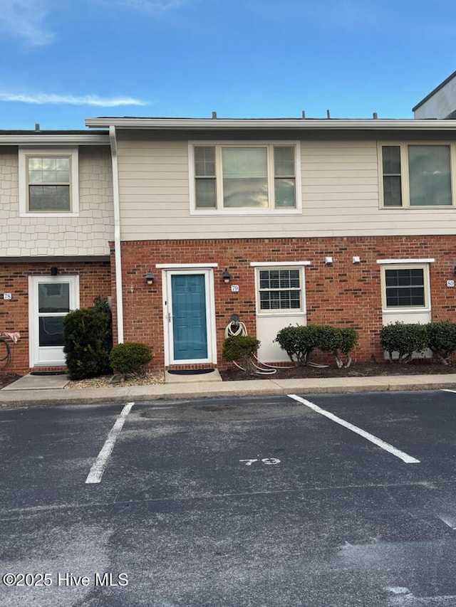 multi unit property with uncovered parking and brick siding