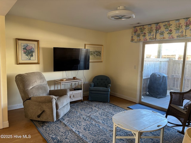 living area with wood finished floors, visible vents, and baseboards