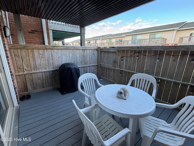 view of wooden balcony with outdoor dining space, a wooden deck, and area for grilling