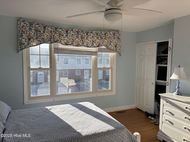 bedroom with a ceiling fan, multiple windows, baseboards, and dark wood-type flooring