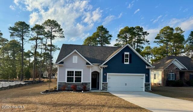 craftsman house featuring an attached garage, driveway, and stone siding