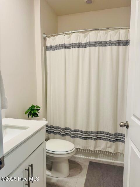 full bathroom featuring a shower with curtain, vanity, toilet, and tile patterned floors