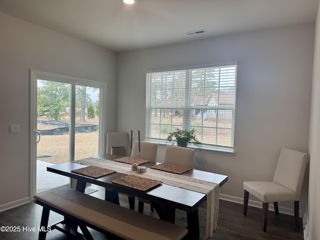 dining area with wood finished floors, visible vents, and baseboards