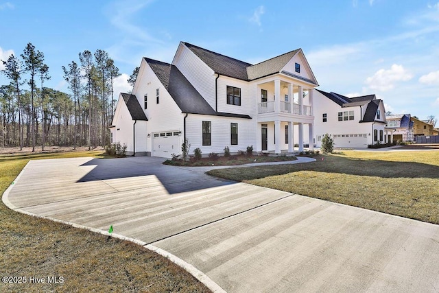 view of front of property with a garage, driveway, a balcony, and a front lawn