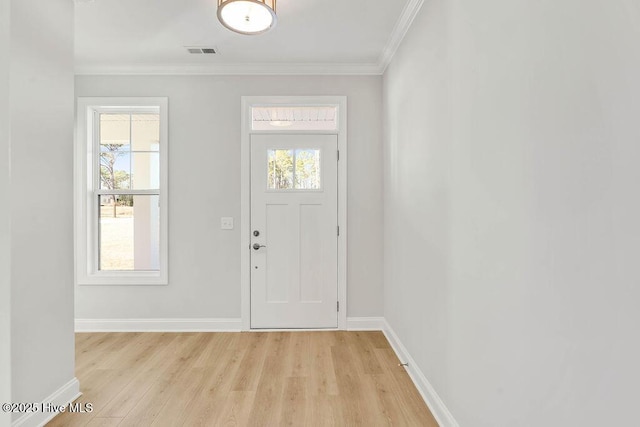 entrance foyer featuring light wood-style floors, visible vents, crown molding, and baseboards