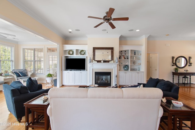2906 Legends Dr, Southport, NC 28461 - living area with ceiling fan, wood finished floors, crown molding, and a glass covered fireplace