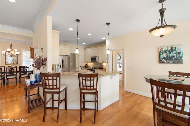 2906 Legends Dr, Southport, NC 28461 - kitchen featuring stainless steel appliances, a breakfast bar, ornamental molding, light stone countertops, and light wood-style floors