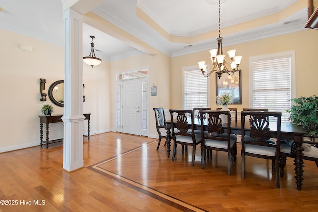 2906 Legends Dr, Southport, NC 28461 - dining space with light wood-style floors, a chandelier, decorative columns, and crown molding
