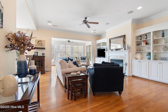 2906 Legends Dr, Southport, NC 28461 - living room featuring a glass covered fireplace, a ceiling fan, light wood finished floors, crown molding, and recessed lighting