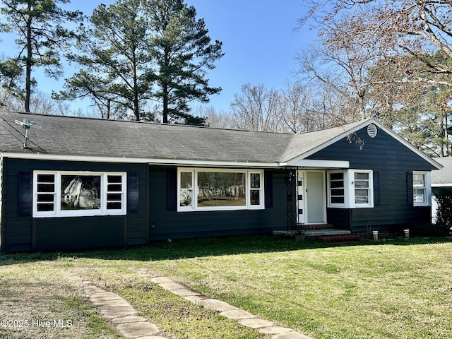 ranch-style house with a shingled roof and a front yard