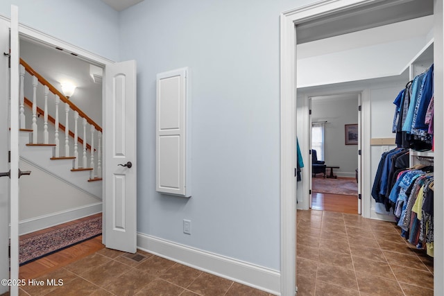 hall with stairway, baseboards, visible vents, and tile patterned flooring