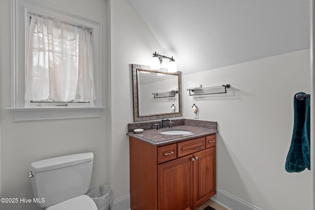 bathroom featuring lofted ceiling, toilet, and vanity