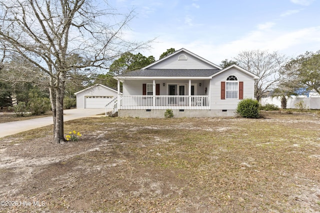 view of front of house featuring an outbuilding, a detached garage, a shingled roof, covered porch, and crawl space