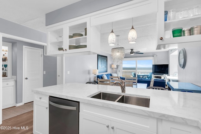 kitchen with a sink, dishwasher, open floor plan, and white cabinets