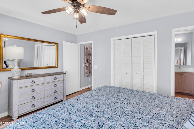 bedroom with a ceiling fan, baseboards, a sink, a closet, and ensuite bathroom