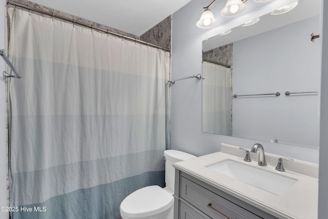 bathroom with vanity, curtained shower, and toilet