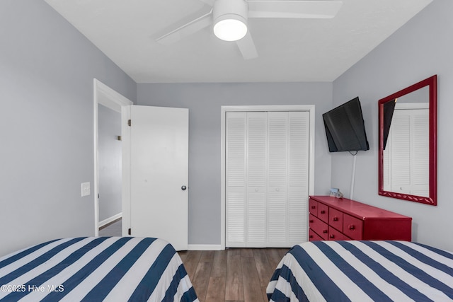 bedroom featuring a closet, baseboards, dark wood finished floors, and a ceiling fan