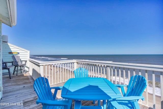 wooden terrace with a view of the beach and a water view