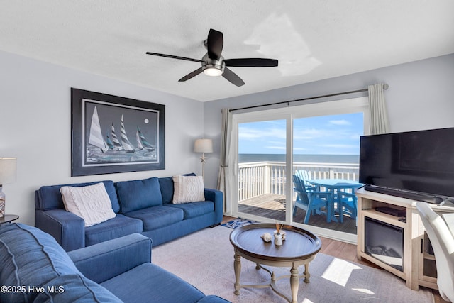 living area featuring a textured ceiling, ceiling fan, and wood finished floors