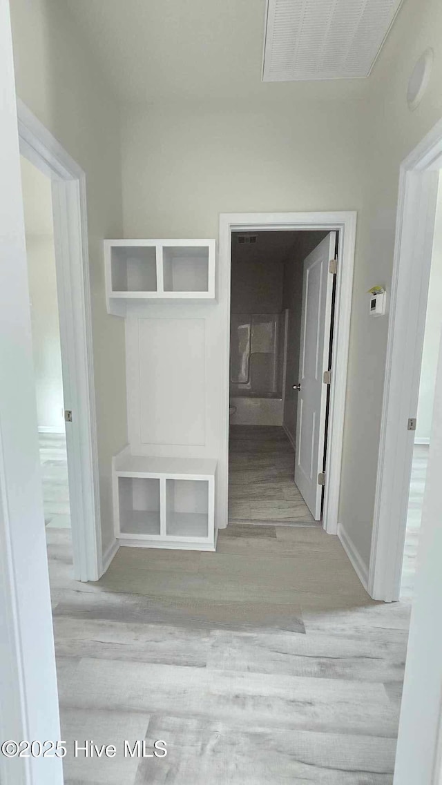 mudroom with wood finished floors, visible vents, and baseboards