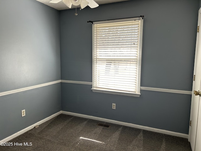 empty room with visible vents, baseboards, carpet, and ceiling fan