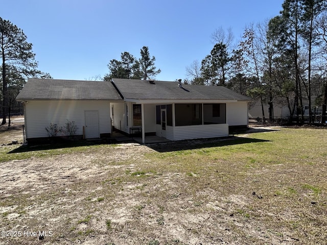 rear view of property with a yard and a sunroom