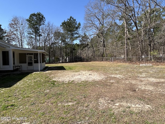 view of yard featuring fence and a sunroom