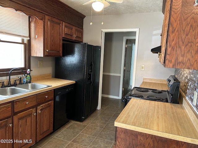 kitchen featuring ventilation hood, a sink, black appliances, a textured ceiling, and dark tile patterned floors