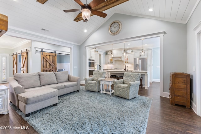 living area featuring baseboards, visible vents, ceiling fan, dark wood-type flooring, and a barn door