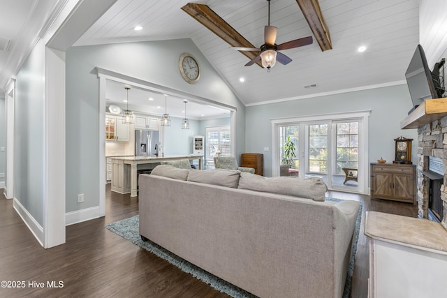 living area featuring dark wood-type flooring, plenty of natural light, a fireplace, and vaulted ceiling