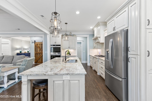 kitchen featuring visible vents, open floor plan, ornamental molding, stainless steel appliances, and a sink