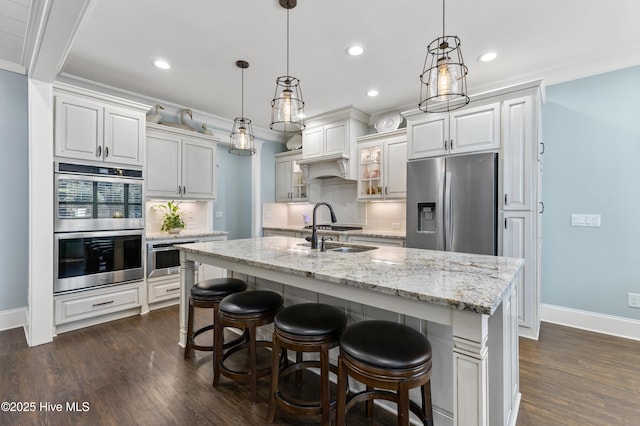 kitchen with dark wood-style flooring, tasteful backsplash, appliances with stainless steel finishes, and a sink