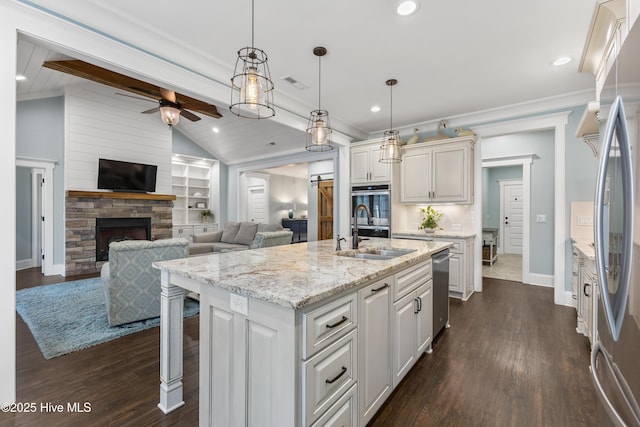 kitchen featuring visible vents, lofted ceiling with beams, stainless steel appliances, a sink, and crown molding