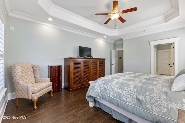 bedroom with recessed lighting, a tray ceiling, wood finished floors, and crown molding