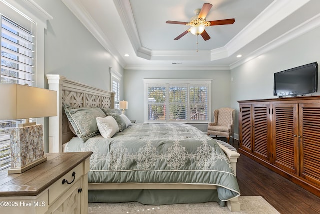 bedroom featuring a tray ceiling, crown molding, recessed lighting, and wood finished floors