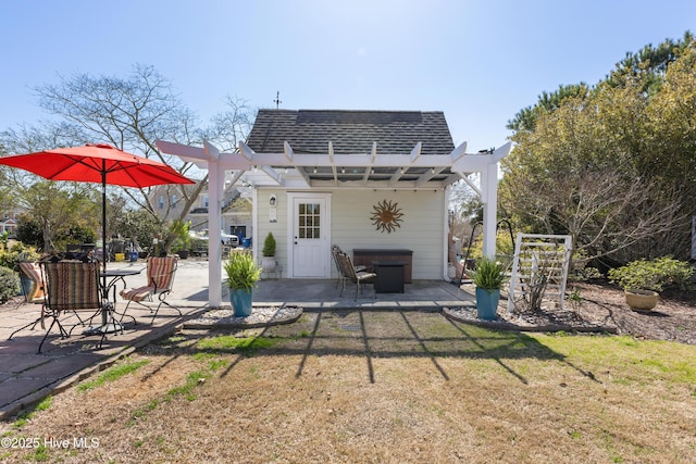 rear view of property featuring a lawn, a pergola, mansard roof, a shingled roof, and a patio area