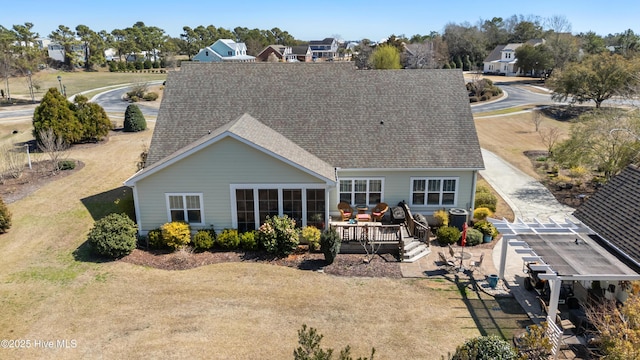 rear view of property with a deck and roof with shingles