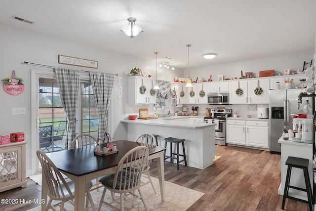 dining space with visible vents and wood finished floors